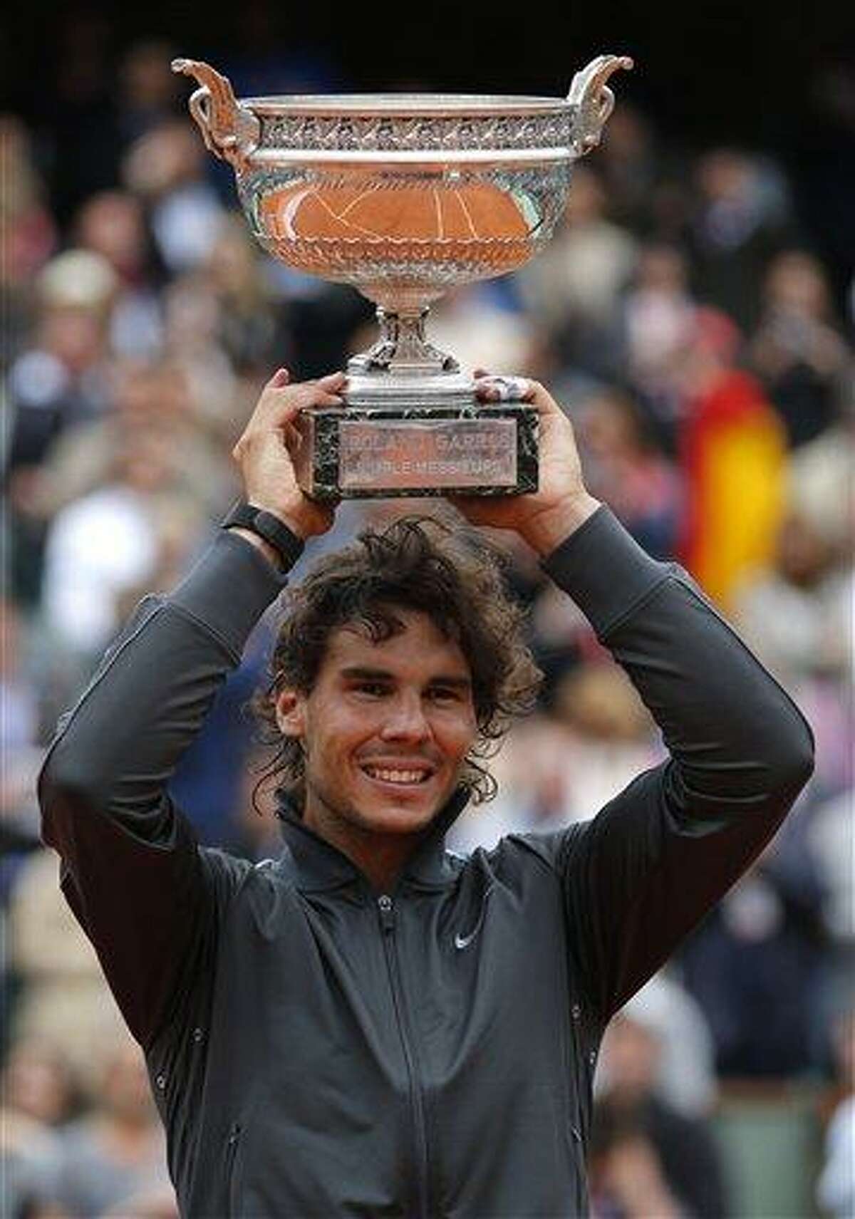 Spain's Rafael Nadal holds the cup after defeating Serbia's Novak Djokovic after their men's final match in the French Open tennis tournament at the Roland Garros stadium Monday in Paris. Nadal passes Bjorn Borg as the all-time record-holder for French Open titles. Associated Press