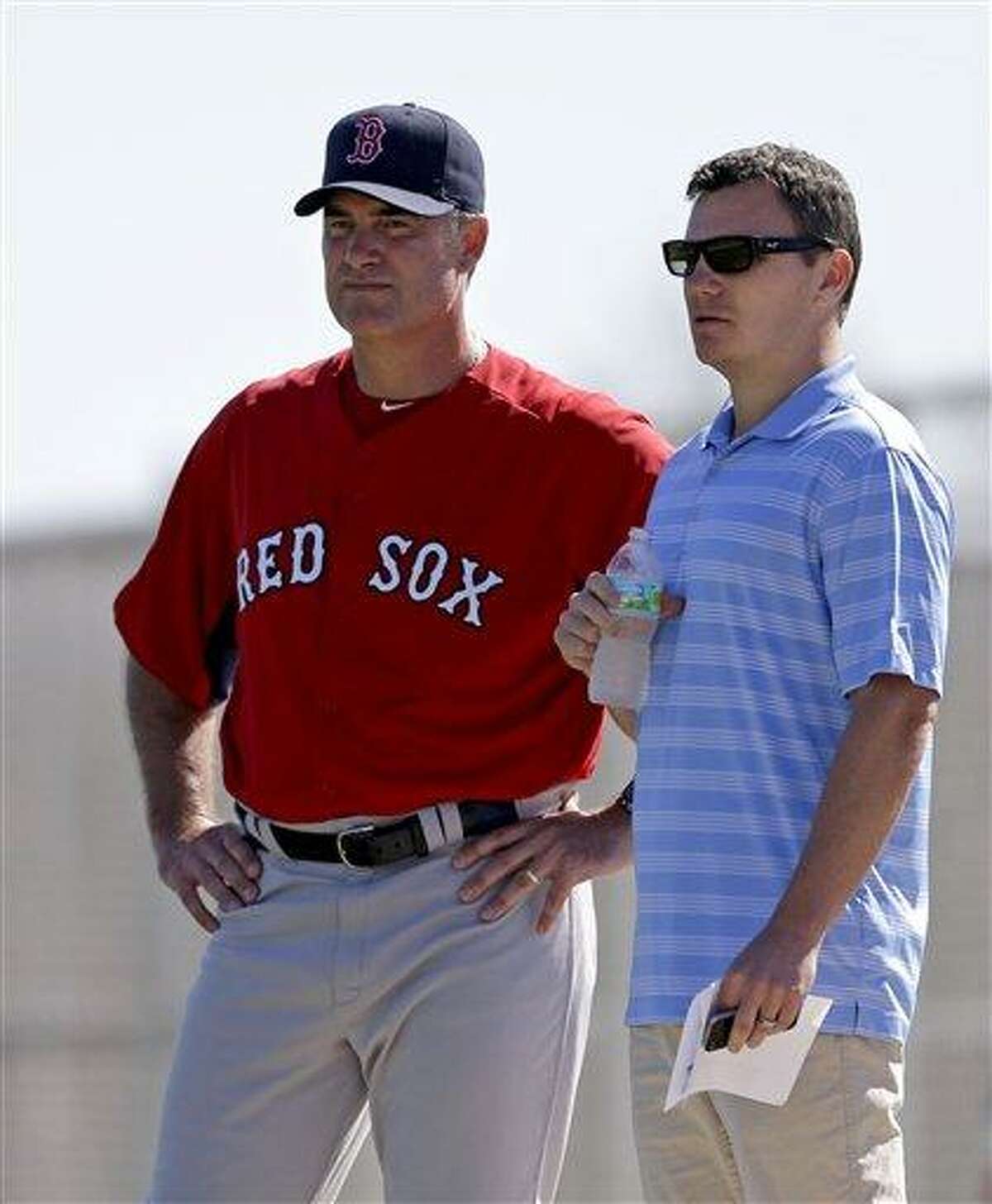 Boston Red Sox manager John Farrell, left, and general manager Ben Cherington, watch as Alfredo Aceves pitches batting practice during a spring training baseball workout, Wednesday, Feb. 20, 2013, in Fort Myers, Fla. (AP Photo/David Goldman)