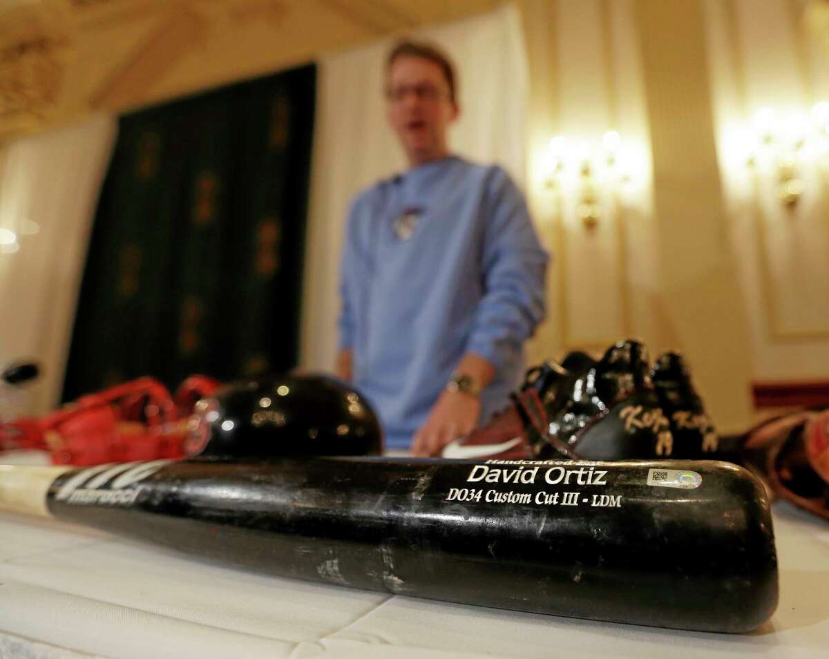 Brad Horn of the Baseball Hall of Fame displays a bat used by Boston Red Sox designated hitter David Ortiz in the World Series during a news conference on Thursday in Colonie, N.Y. Items from the series are headed to Cooperstown and will be on display in the Hall’s Autumn Glory exhibit. The Red Sox won the series by defeating the St. Louis Cardinals in six games.