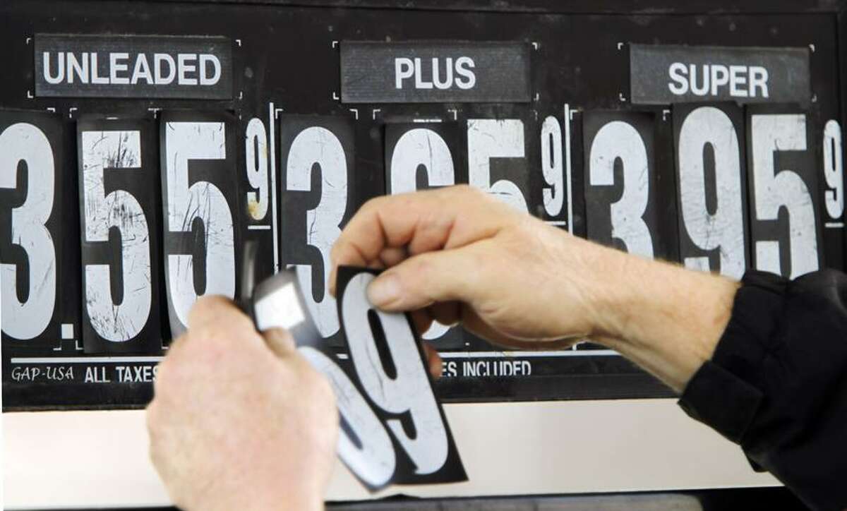 Gas station manager Fred Oliver, of Lisbon Falls, Maine, changes the price of gasoline on the pumps at a station in Topsham, Maine. Associated Press