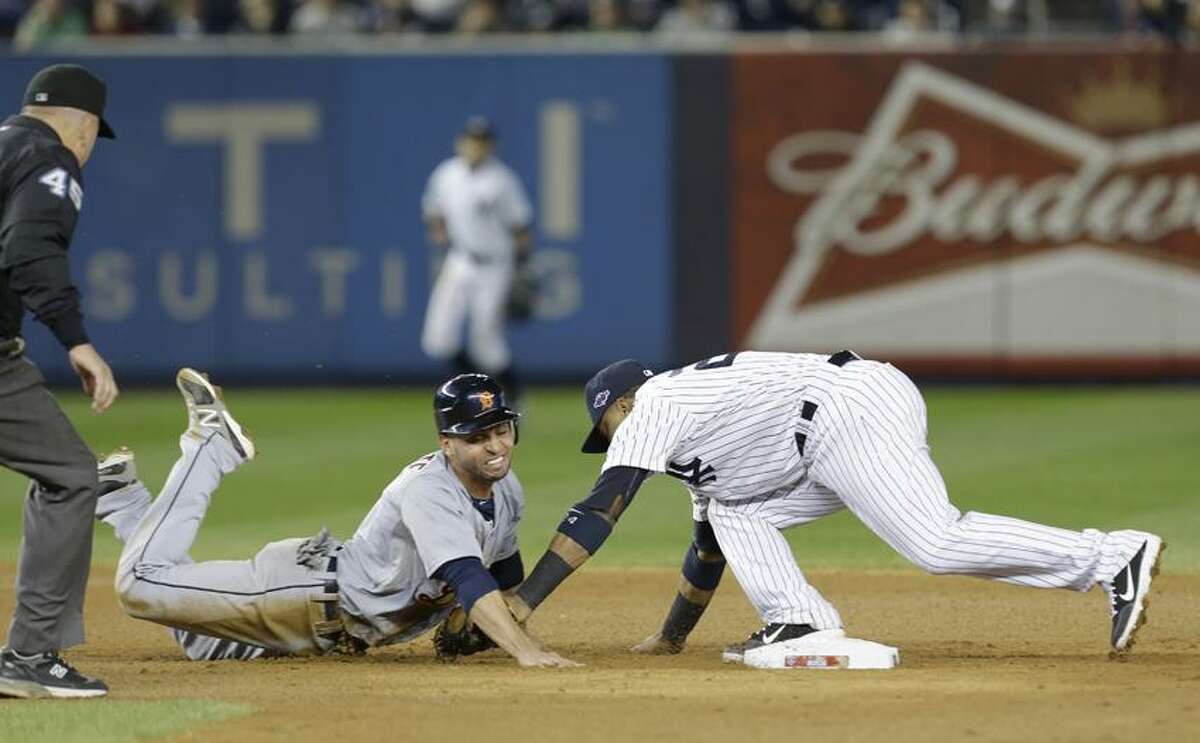 Detroit Tigers' Omar Infante dives back into second as New York Yankees' Robinson Cano reaches to tag him in the eighth inning of Game 2 of the American League championship series Sunday, Oct. 14, 2012, in New York. Infante was called safe on the play by umpire Jeff Nelson. (AP Photo/Paul Sancya )
