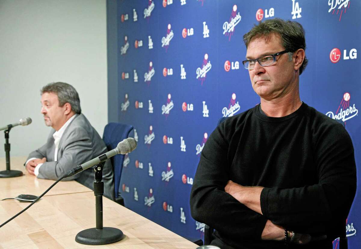 Los Angeles general manager Ned Colletti, left, manager Don Mattingly and the Dodgers are favorites to win the 2014 World Series.