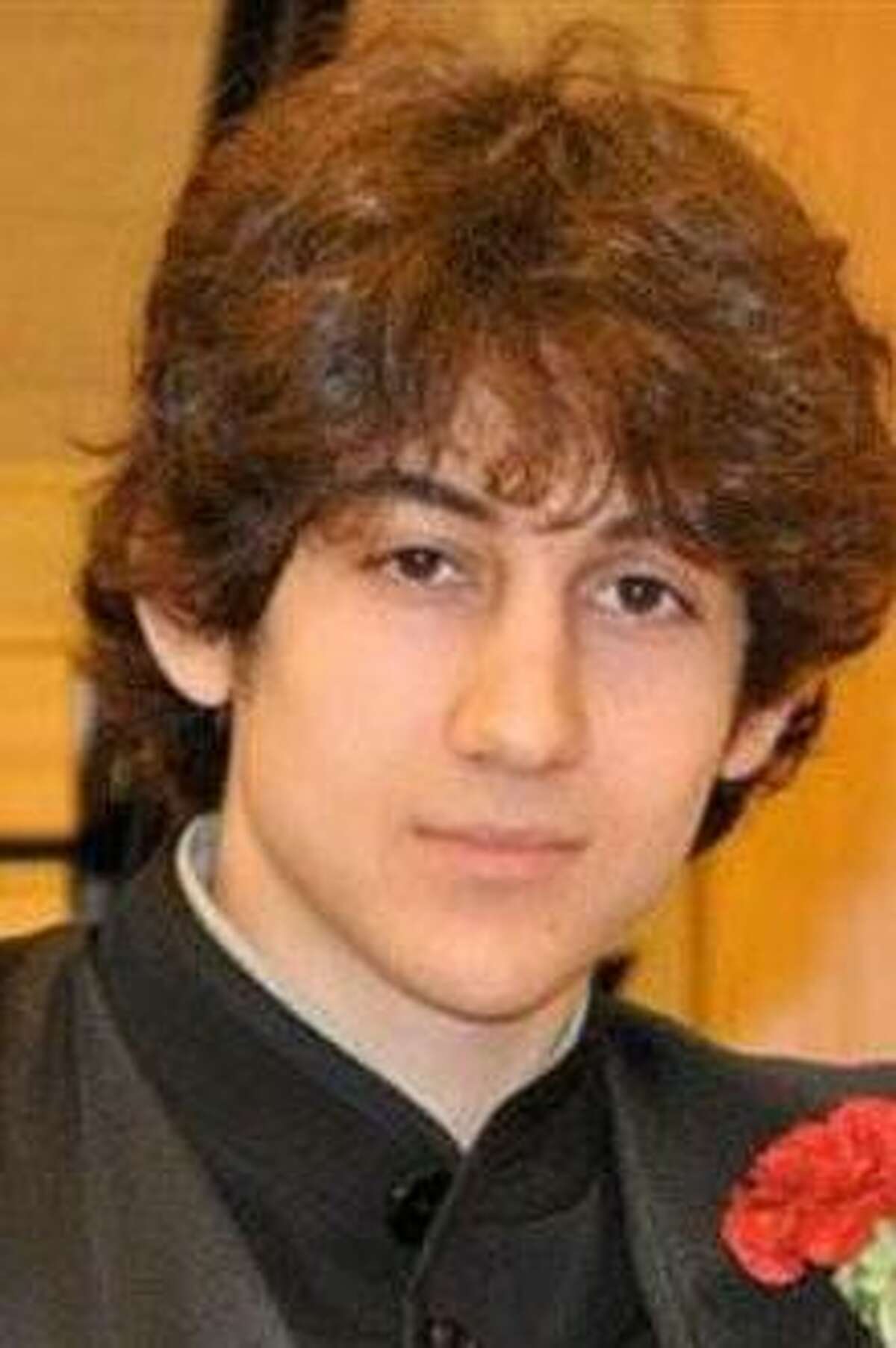In this undated photo provided by Robin Young, Dzhokhar A. Tsarnaev poses for a photo after graduating from Cambridge Rindge and Latin High School. Tsarnaev has been identified as the surviving suspect in the marathon bombings. Two suspects in the Boston Marathon bombing killed an MIT police officer, injured a transit officer in a firefight and threw explosive devices at police during a getaway attempt in a long night of violence that left one of them dead and another still at large Friday, April 19, 2013. (AP Photo/Robin Young)