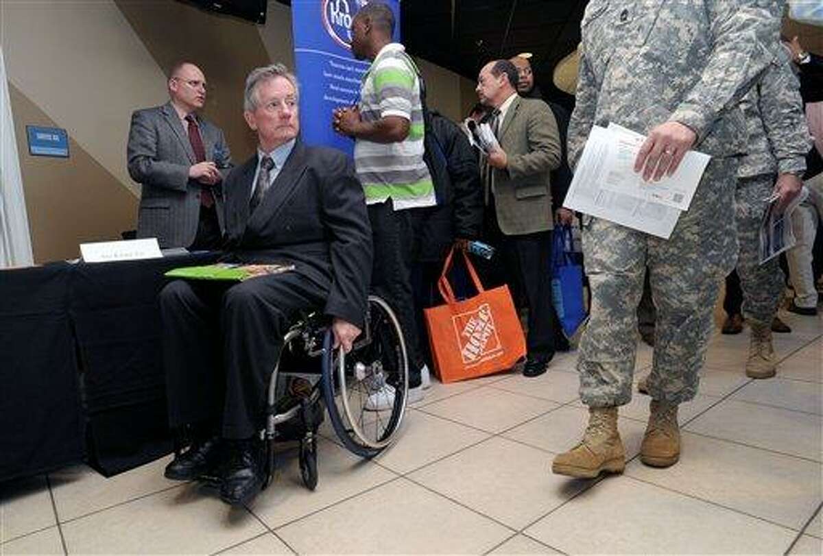 Disabled army veteran Ken Higgins, of Lilburn, Ga., finishes with a recruiter as he and other veterans attend a military-to-civilian job and education fair held Feb. 9 at Turner Field, in Atlanta. General Electric Co. plans to hire 5,000 veterans over the next five years and invest $580 million to expand its aviation business. Associated Press