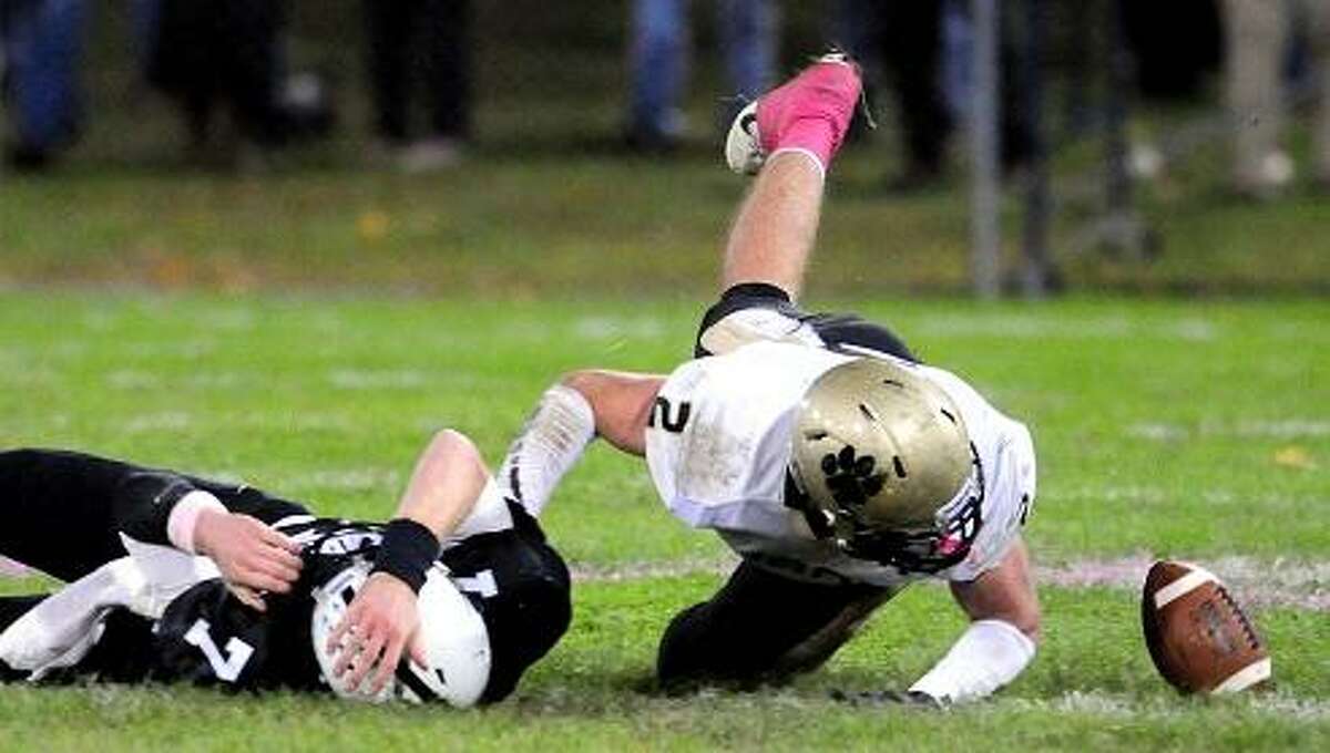 Xavier quarterback Tim Doyle (left) fumbles the ball against Daniel Hand in the first half at Palmer Field in Middletown on 10/12/2012. Peter Gerson (right) of Daniel Hand recovered the ball on the play.Photo by Arnold Gold/New Haven Register