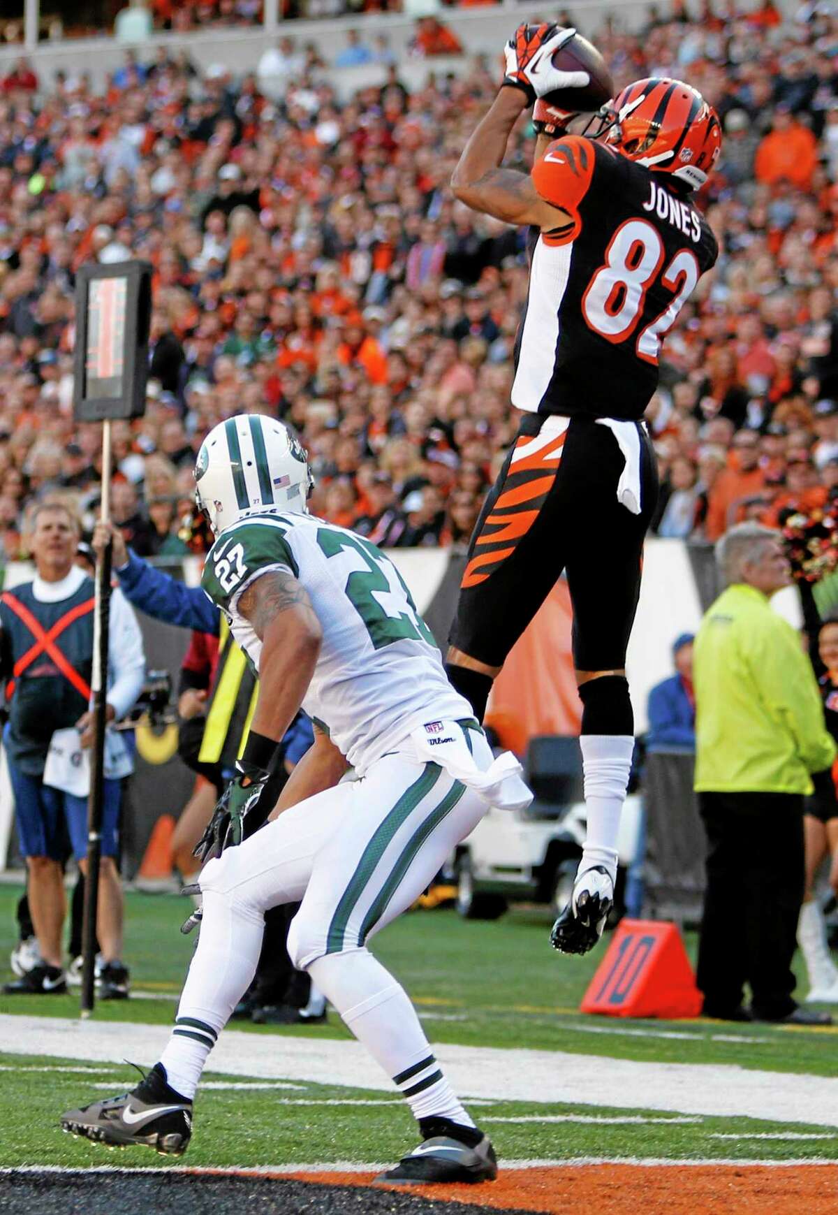 Bengals wide receiver Marvin Jones (82) catches a nine-yard touchdown pass against New York Jets cornerback Dee Milliner (27) in the first half of Sunday’s game in Cincinnati.