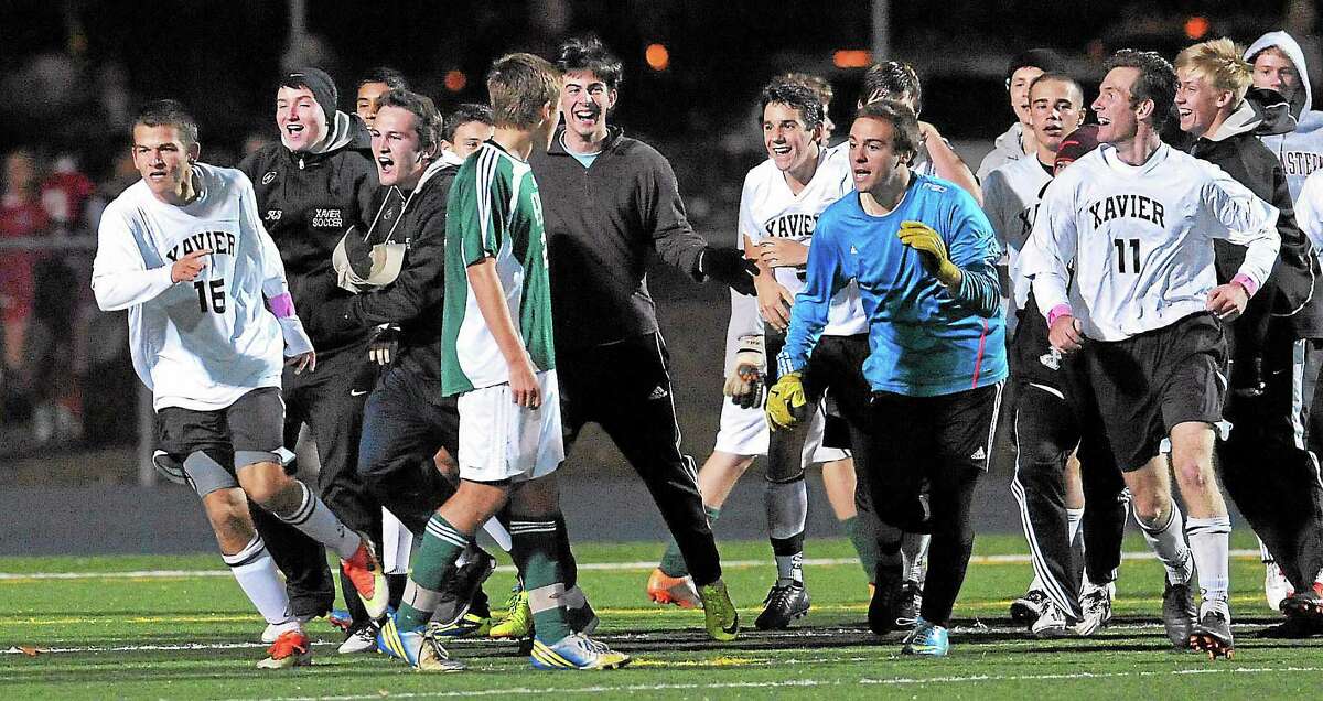 Xavier celebrates after Brendan Cutuli (far left) scored in the second overtime period to beat Guilford 2-1 in the SCC Soccer Championship in East Haven on 10/30/2013.