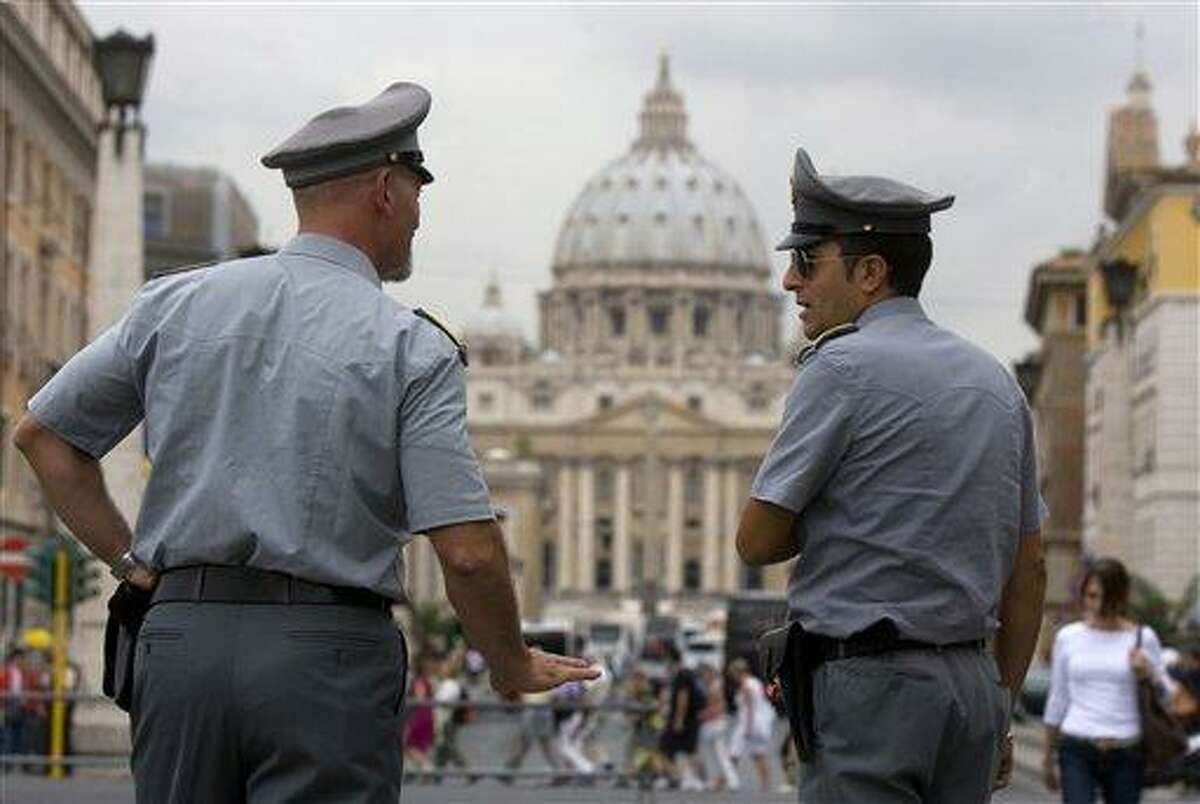In this 2010 file photo, Italian police officers talk in front of St. Peter's Square at the Vatican. The Vatican is being besieged by near daily leaks of confidential documents and tabloid-style reports about alleged money laundering at the Vatican bank, and in news reports today on Philadelphia Cardinal Anthony Bevilacqua, some conspiracy theories cast a shadow on the upcoming crowning of 22 new cardinals, who will be partly responsible for electing the successor to the pope himself. Associated Press