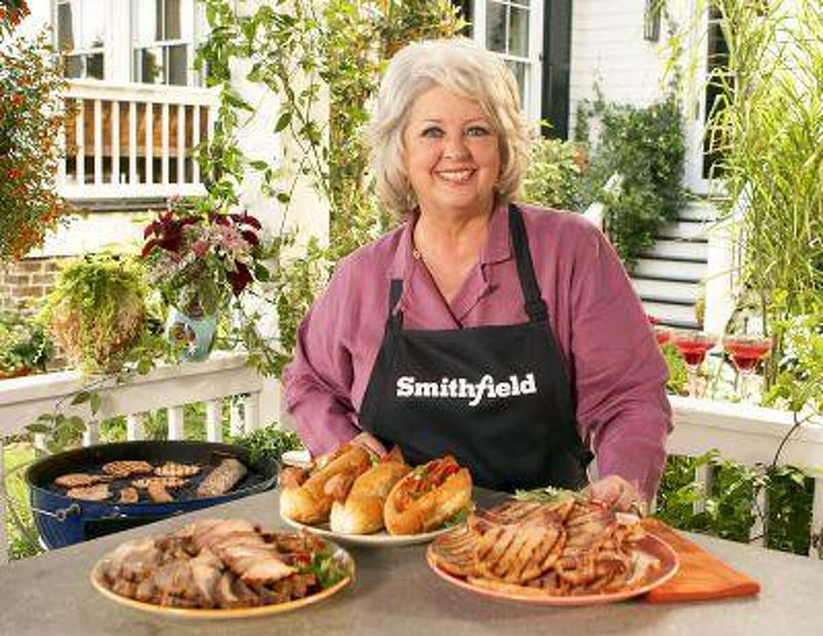 This undated image released by Smithfield Foods shows celebrity chef Paula Deen wearing a Smithfield apron as she stands in front of various Smithfield meat products. On Monday, June 24, 2013, Smithfield Foods said it was dropping Deen as a spokeswoman. The announcement came days after the Food Network said it would not renew the celebrity cook's contract in the wake of revelations that she used racial slurs in the past. (AP Photo/Smithfield Foods via PRNewsFoto)