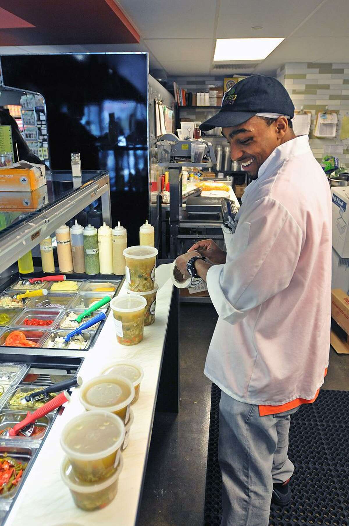 New Haven-- Terry Williams fills soups for customers at the new Elm City Market at 360 State Street. Williams, an ex-offender got the job at the city Re-Entry Roundtable job fair held in October. Peter Casolino/New Haven Register02/07/12