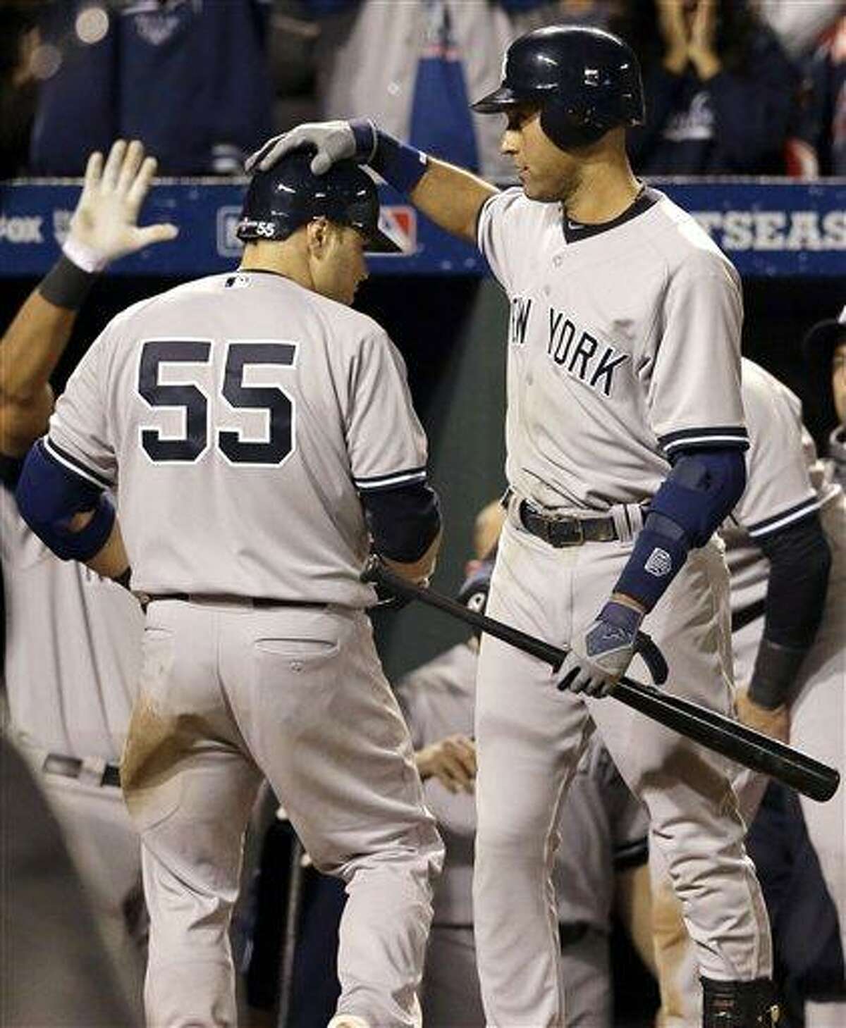 New York Yankees' Derek Jeter, right, congratulates teammate Russell Martin after Martin hit a solo home run in the ninth inning of Game 1 of the American League division baseball series against the Baltimore Orioles on Sunday, Oct. 7, 2012, in Baltimore. New York won 7-2. (AP Photo/Patrick Semansky)