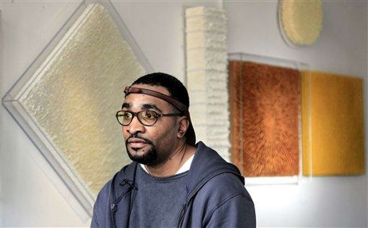 Lerone Wilson, a Harlem artist who creates unique sculptural paintings with molten beeswax, listens during an interview Wednesday in New York. Associated Press