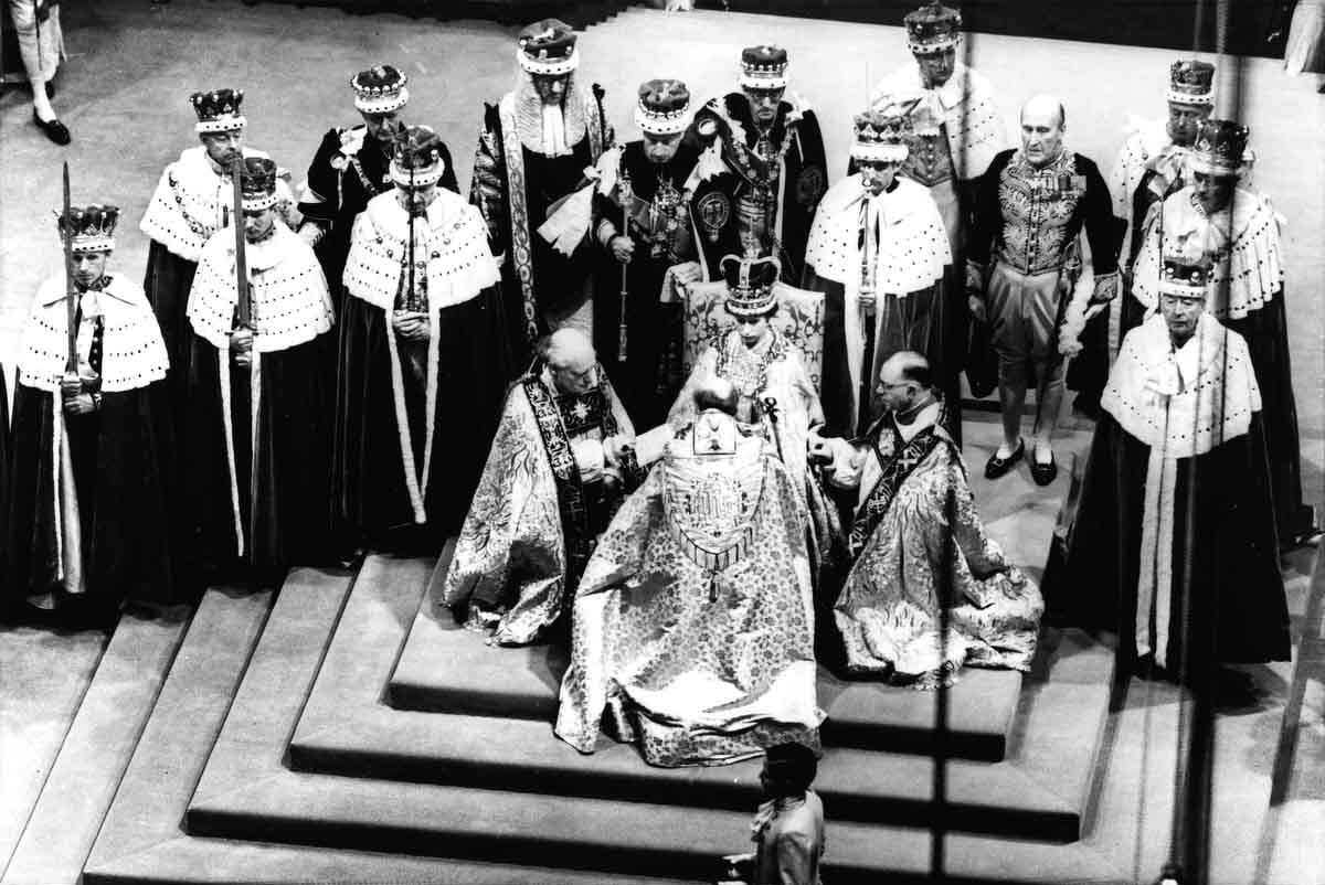 In this June 2, 1953 file photo, Britain's Queen Elizabeth II, seated on the throne, receives the fealty of the Archbishop of Canterbury, back to camera at center, the Bishop of Durham, left and the Bishop of Bath and Wells, during her coronation in Westminster Abbey, London. Associated Press file photo