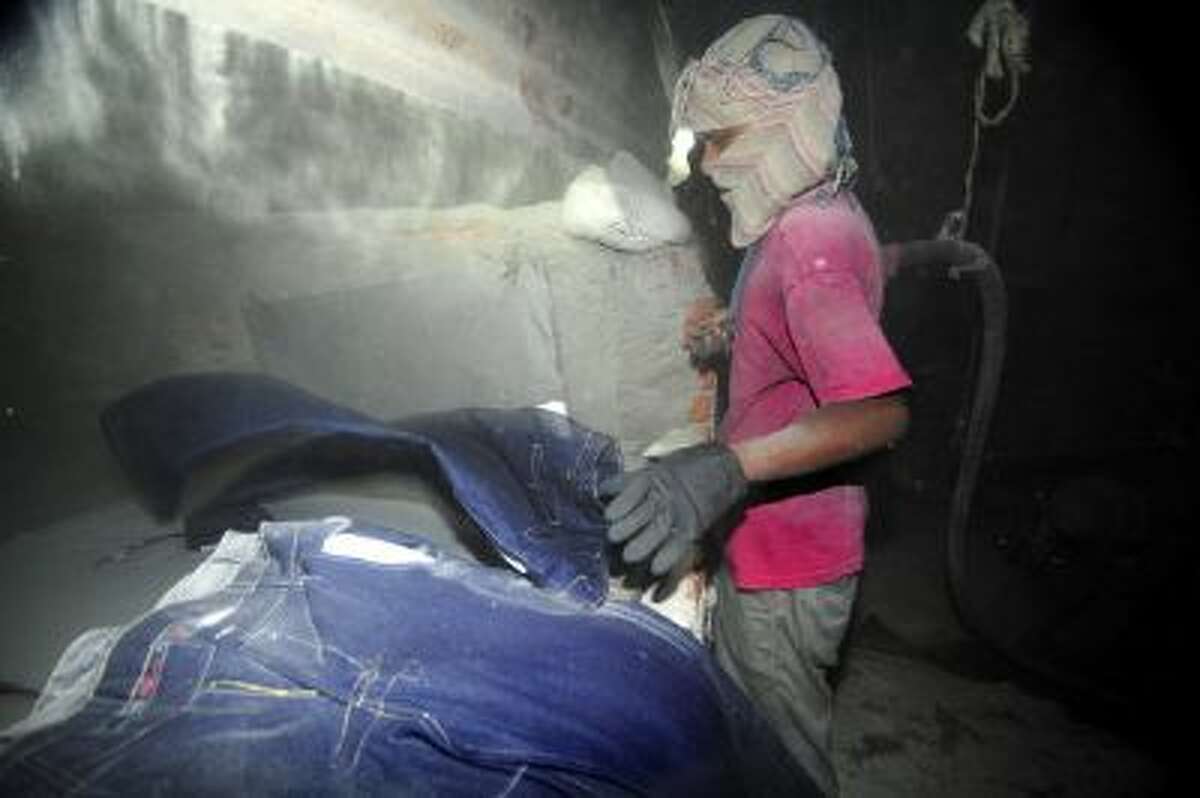 A Bangladeshi garment laborer works in a sandblasting factory in Dhaka, 2011.