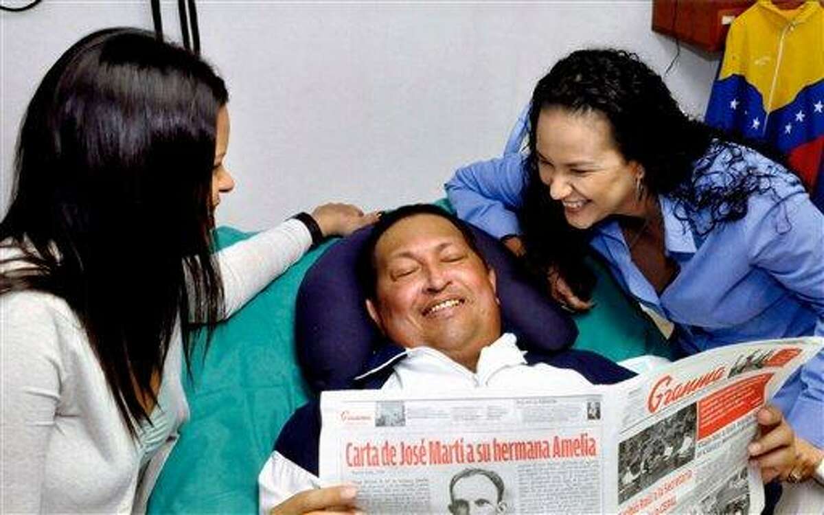 In this photo released Friday, Feb. 15, 2013 by Miraflores Presidential Press Office, Venezuela's President Hugo Chavez, center, poses for a photo with his daughters, Maria Gabriela, left, and Rosa Virginia as he holds a copy of Cuba's state newspaper Granma at an unknown location in Havana, Cuba, Thursday, Feb. 14, 2013. Chavez remains in Havana undergoing unspecified treatments following his fourth cancer-related operation on Dec. 11. He has hasn't been seen or spoken publicly in more than two months. (AP Photo/Miraflores Presidential Press Office)