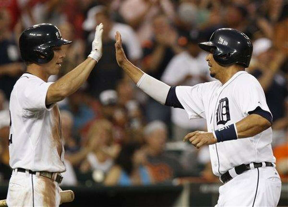 Detroit Tigers' Victor Martinez, right, gets a high-five from Andy Dirks after scoring from second base on a single by Jhonny Peralta in the fifth inning of a baseball game Saturday, June 22, 2013, in Detroit. (AP Photo/Duane Burleson)