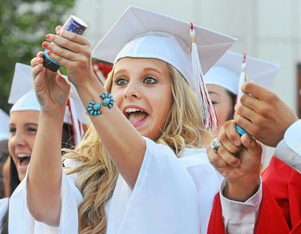 Catherine Avalone/The Middletown Press Haley Kobos works out releasing the confetti as her classmates from class of 2013 at Cromwell High School graduation celebrate Friday evening.