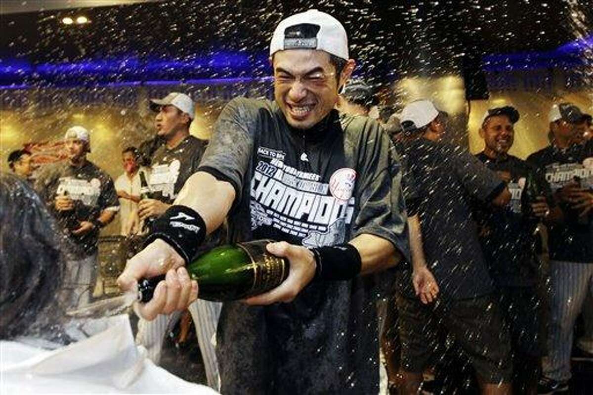 New York Yankees' Ichiro Suzuki douses the team photographer as teammates celebrate in the clubhouse after their 14-2 win over the Boston Red Sox in a baseball game and clinched the American League East title at Yankee Stadium in New York, Wednesday, Oct. 3, 2012. (AP Photo/Kathy Willens)