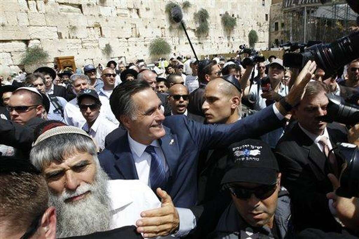 Republican presidential candidate and former Massachusetts Gov. Mitt Romney greets the crowd after he visited the Western Wall, rear, in the Old City of Jerusalem, Sunday, July 29, 2012. Associated Press