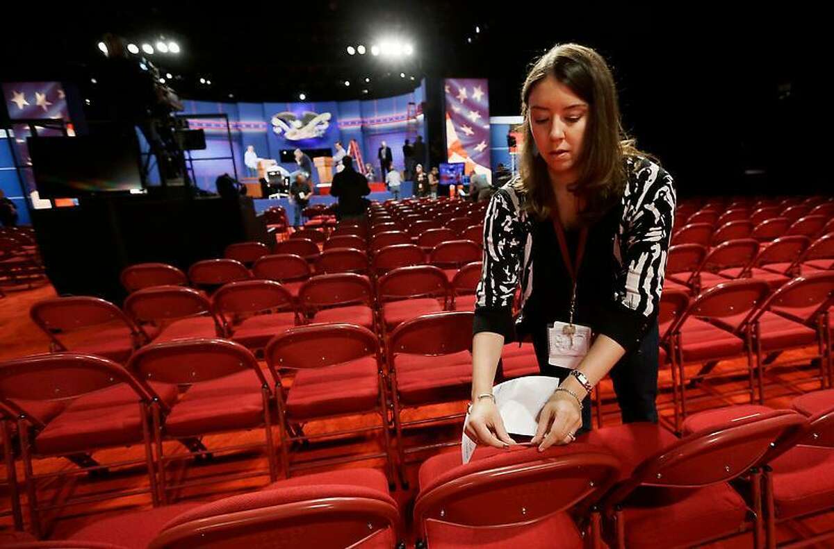 A worker labels chairs in the Magness Arena, site of tonight's presidential debate, on the campus of the University of Denver. Associated Press