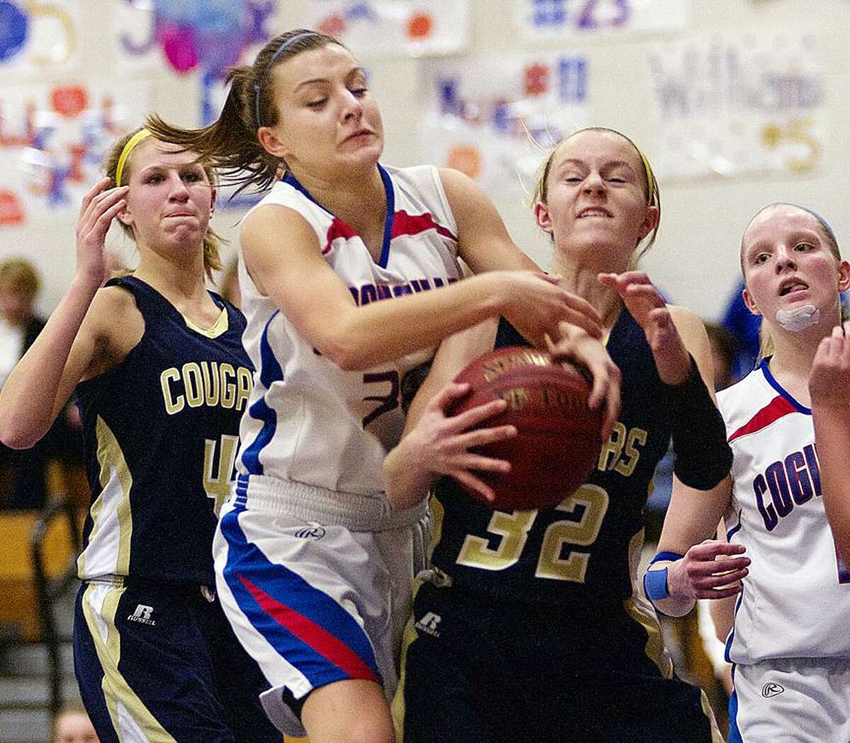 Catherine Avalone/The Middletown Press Coginchaug senior Jessica Solomon battles H-K sophomore Halie Serbent for a rebound. At left is Kiley Anderson (4) and junior forwardMorgan Kuehnle at right. The H-K Cougars came from behind to defeat the Coginchaug Blue Devils 43-39.