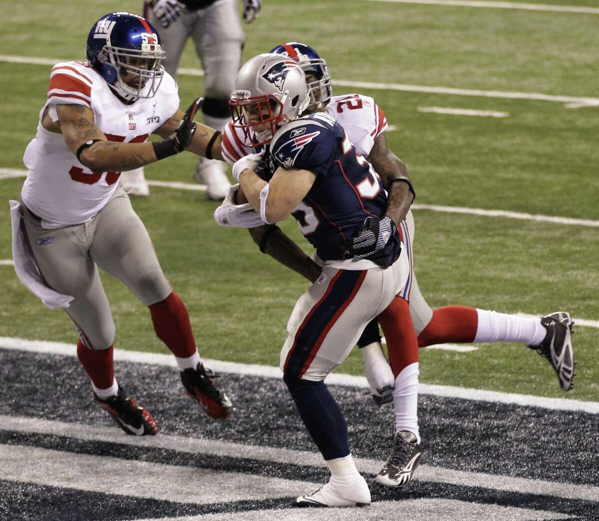 New England Patriots running back Danny Woodhead (39) scores a touchdown as New York Giants Michael Boley (59) and Kenny Phillips (21) fail to stop him during the first half of their NFL Super Bowl XLVI football game, Sunday, Feb. 5, 2012, in Indianapolis. (AP Photo/Elise Amendola)