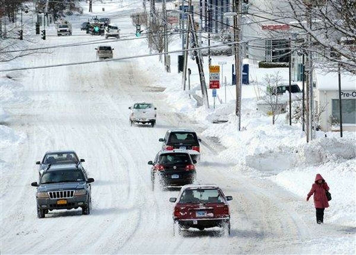 Cars drive along West Putnam Avenue during the aftermath of a blizzard in Greenwich, Conn., Saturday morning, Feb. 9, 2013. (AP Photo/Greenwich Time, Bob Luckey) MANDATORY CREDIT; MAGS OUT