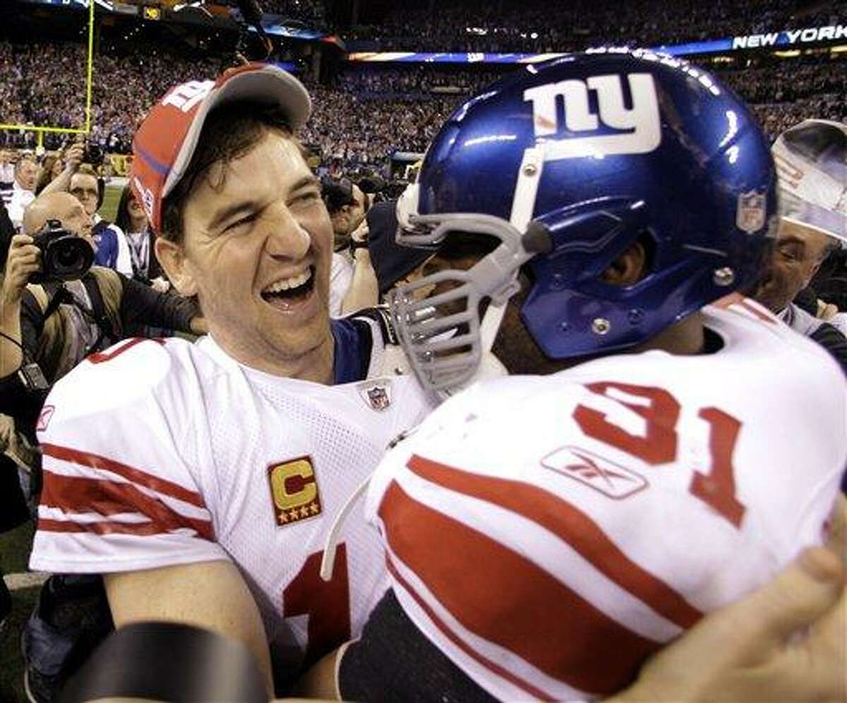 New York Giants quarterback Eli Manning, left, and Aaron Ross celebrate their team's 21-17 win over the New England Patriots in the NFL Super Bowl XLVI football game, Sunday, Feb. 5, 2012, in Indianapolis. (AP Photo/Eric Gay)