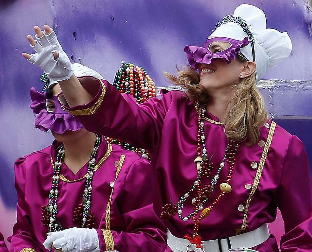 A mask rider in the Iris Mardi Gras parade waves from the float as it rolls through the streets of New Orleans, Saturday, Feb. 9, 2013.(AP Photo/Bill Haber)