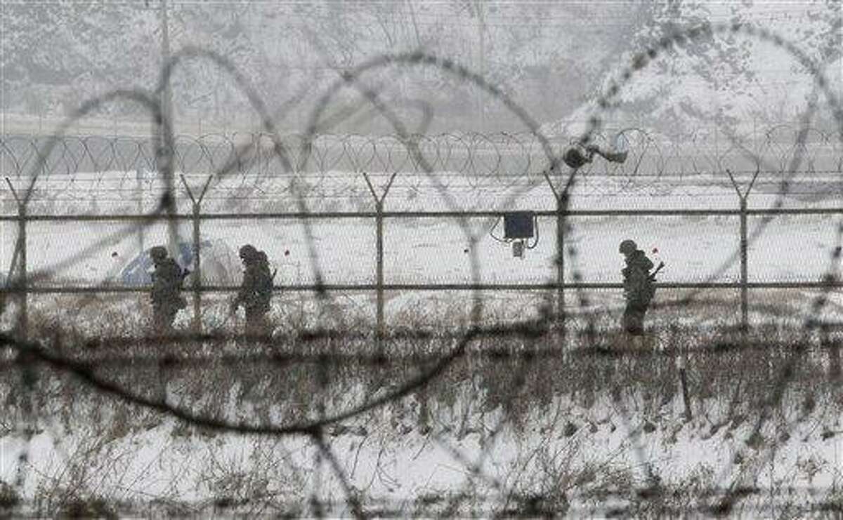 South Korean army soldiers patrol along barbed-wire fences at the Imjingak Pavilion, near the demilitarized zone of Panmunjom, in Paju, South Korea, Tuesday, Feb. 12, 2013. South Korea is confirming that North Korea has tested a nuclear device in defiance of U.N. orders to stop building atomic weapons. (AP Photo/Ahn Young-joon)