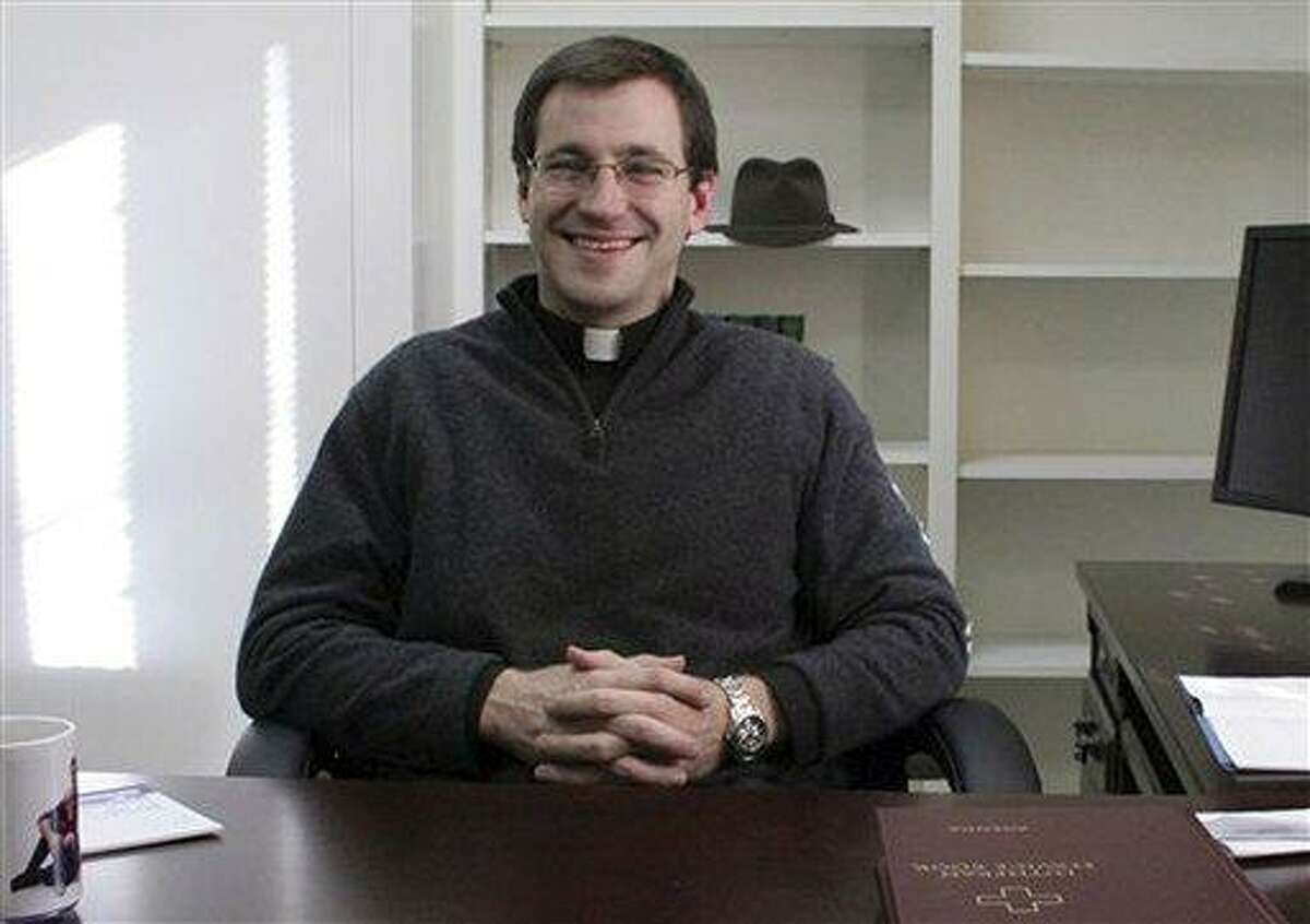 In this January 2012 photo provided by the Newtown Bee, the Rev. Rob Morris sits in his office at Christ the King Lutheran Church in Newtown, Conn. The Lutheran Church-Missouri Synod denomination is reprimanding Rev. Morris for participating in an interfaith vigil on Dec. 16, 2012, after the Sandy Hook massacre. The denomination bars joint worship because it doesn't want to appear to mix its beliefs with those of other faiths. AP Photo/Newtown Bee, Shannon Hicks