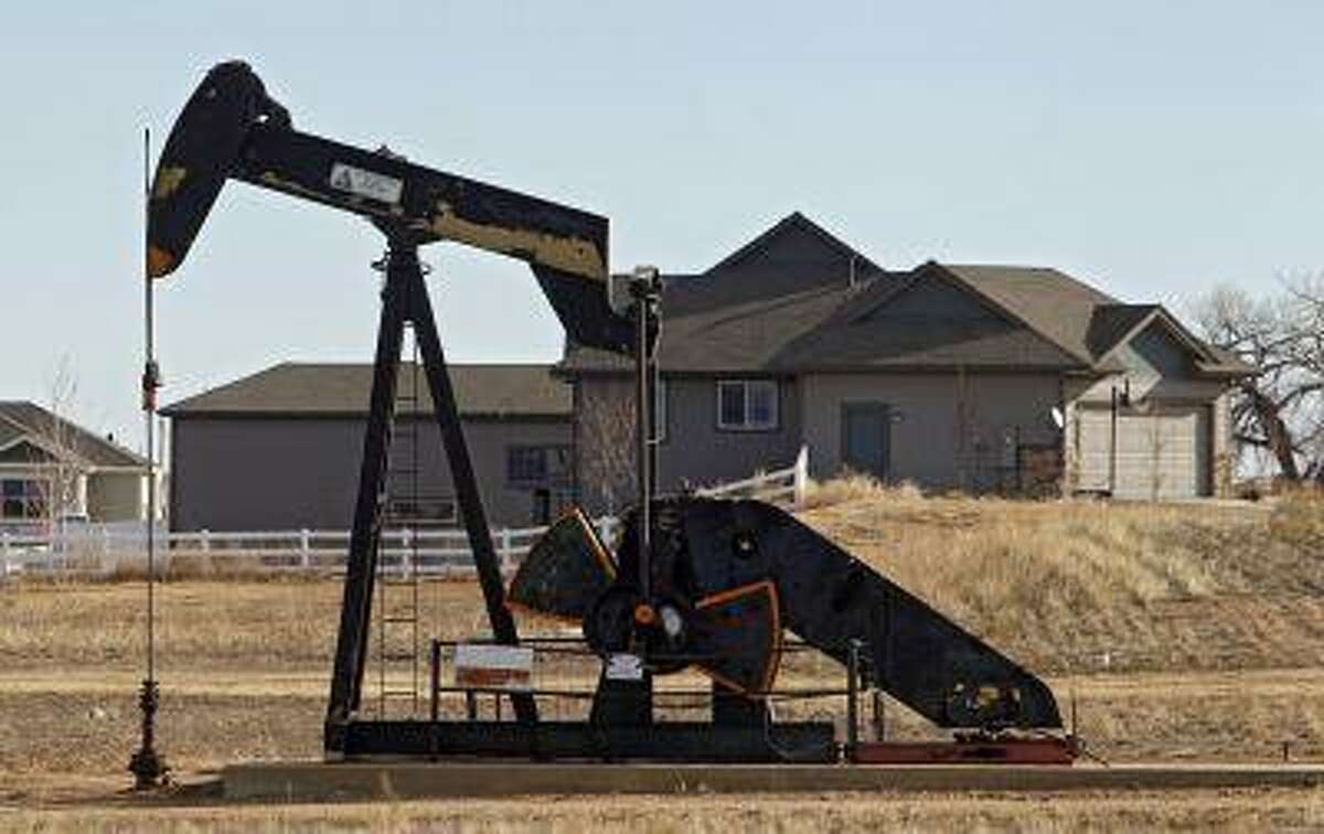 This photo taken on Thursday, Jan. 19, 2012, near Frederick, Colo., shows an oil pump jack working on a property across from a subdivision. (AP Photo/Ed Andrieski)