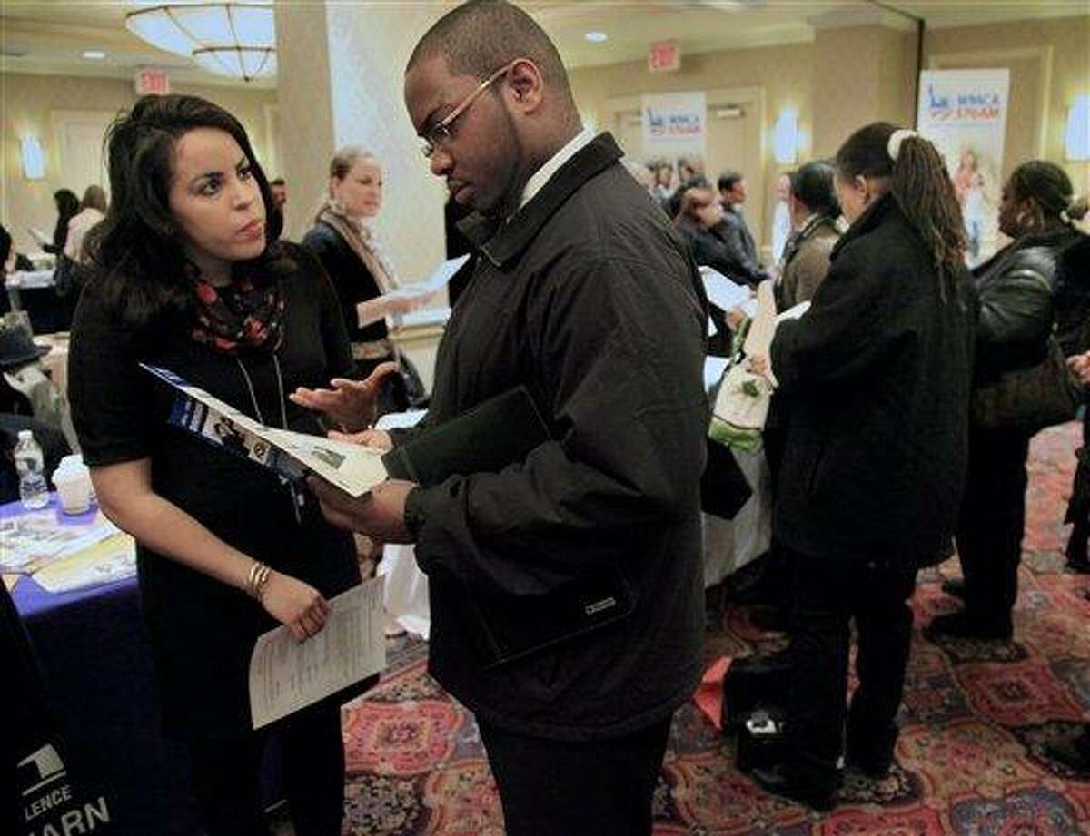 In this Jan. 25 photo, Daniela Silvero, left, an admissions officer at ASA College, discusses job opportunities with Patrick Rosarie, who is seeking a job in IT, during JobEXPO's job fair in New York. The unemployment rate fell for the fifth straight month after a surge of January hiring, a promising shift in the nation's outlook for job growth. Associated Press