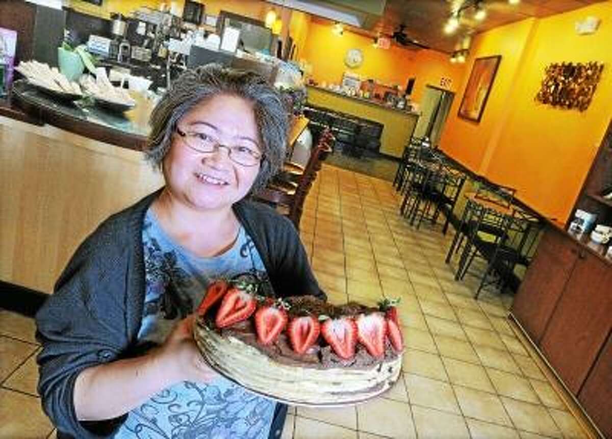 Catherine Avalone/The Middletown Press Trang Tran, baker and manager of Sweet Harmony Cafe & Bakery shows off her Tuxedo Chocolate Mousse Crepe Cake with fresh strawberries at their new location at 330 Main Street in Middletown, formerly Javapalooza. Sweet Harmony moved from Broad Street and will continue to serve coffees and menu items from Javapalooza. "Sweet Harmony offers fresh made crepes made to order and breakfast all day. Gourmet cake to order, you dream it, we can make it." said Tran. Hours are Monday through Friday 6 a.m.-5 p.m. Friday and Saturday 6 a.m. - 7 p.m. and Sunday 7 a.m. - 5 p.m. Visit their website at www.sweetharmonycafebakery.com