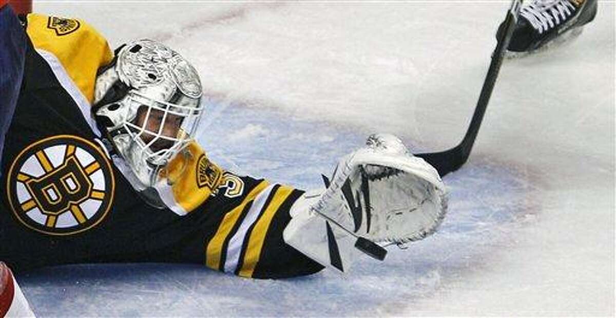 Boston Bruins goalie Tim Thomas (30) reaches out to make a save against the Washington Capitals during the third period of Game 1 of an NHL hockey Stanley Cup first-round playoff series in Boston, Thursday, April 12, 2012. (AP Photo/Charles Krupa)