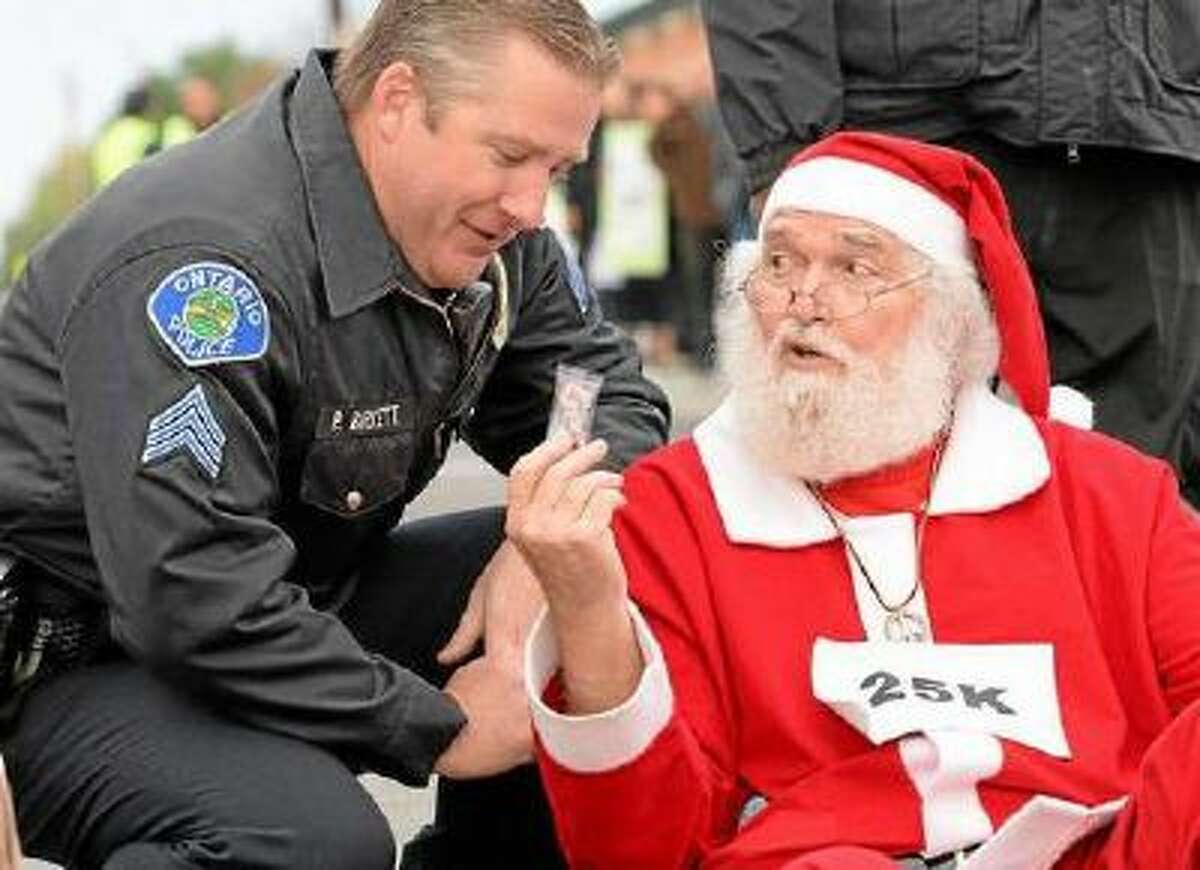Wal-Mart protester Karl Hilgert hands Ontario police department Sgt. Pat Birkett a candy cane as Hilgert is read his rights before being arrested for failure to disperse.