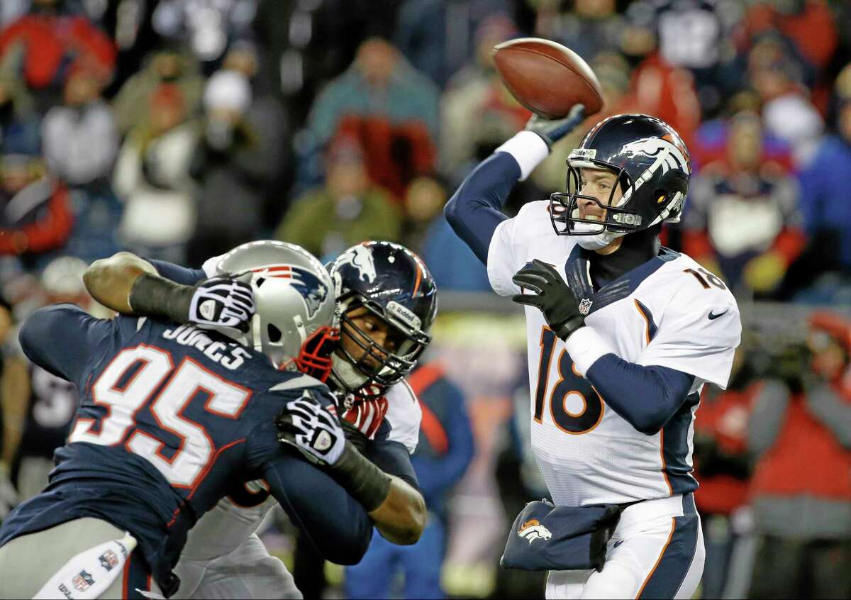 Denver Broncos quarterback Peyton Manning passes against New England Patriots defensive end Chandler Jones (95) in Sunday’s game in Foxborough, Mass.