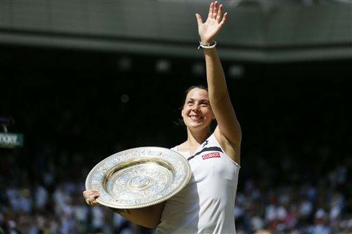 Marion Bartoli of France poses with the trophy after winning against Sabine Lisicki of Germany in the Women's singles final match at the All England Lawn Tennis Championships in Wimbledon, London, Saturday, July 6, 2013. (AP Photo/Stefan Wermuth, Pool)
