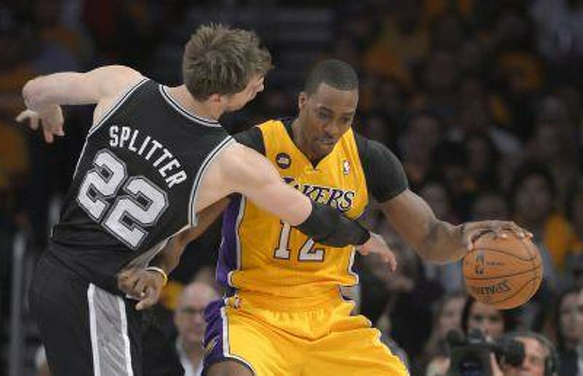 Los Angeles Lakers center Dwight Howard, right, drives around San Antonio Spurs center Tiago Splitter, of Brazil, during the first half in Game 3 of a first-round NBA basketball playoff series, Friday, April 26, 2013, in Los Angeles.