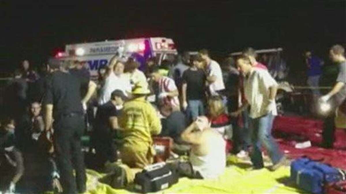 In this frame grab from video provided by Zach Reister, authenticated by checking against known locations and events, and consistent with Associated Press reporting, medical personnel attend the injured after a fireworks show in Simi Valley, Calif., Thursday, July 4, 2013. More than two dozen people were injured when a wood platform holding live fireworks tipped over, sending the pyrotechnics into the crowd at the Fourth of July show, authorities said Friday. (AP Photo/Zach Reister)