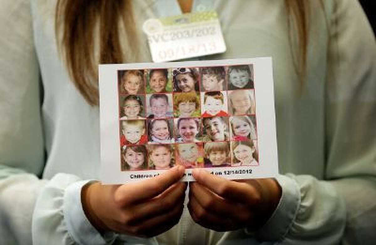 WASHINGTON, DC - SEPTEMBER 18: Kyra Murray holds a photo with victims of the shooting at Sandy Hook Elementary School during a press conference at the U.S. Capitol calling for gun reform legislation and marking the 9 month anniversary of the shooting September 18, 2013 in Washington, DC. With the shooting at the Washington Navy Yard earlier this week, gun reform activists are renewing their call for national reformation of existing gun laws. (Photo by Win McNamee/Getty Images)