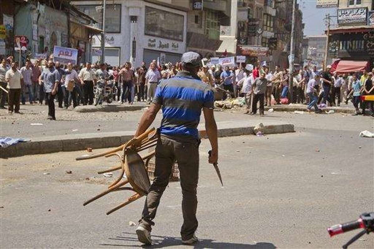 An Egyptian opposition protester holds a chairr and knife during a clash between supporters and opponents of President Mohammed Morsi in downtown Damietta, Egypt, Wednesday, July 3, 2013. he deadline on the military's ultimatum to President Mohammed Morsi has expired, with 48 hours passing since the time it was issued. Giant cheering crowds of Morsi's opponents have been gathered in Cairo's Tahrir Square and other locations nationwide, waving flags furiously in expection that the military will act to remove the Islamist president after the deadline ends.(AP Photo/Hamada Elrasam)