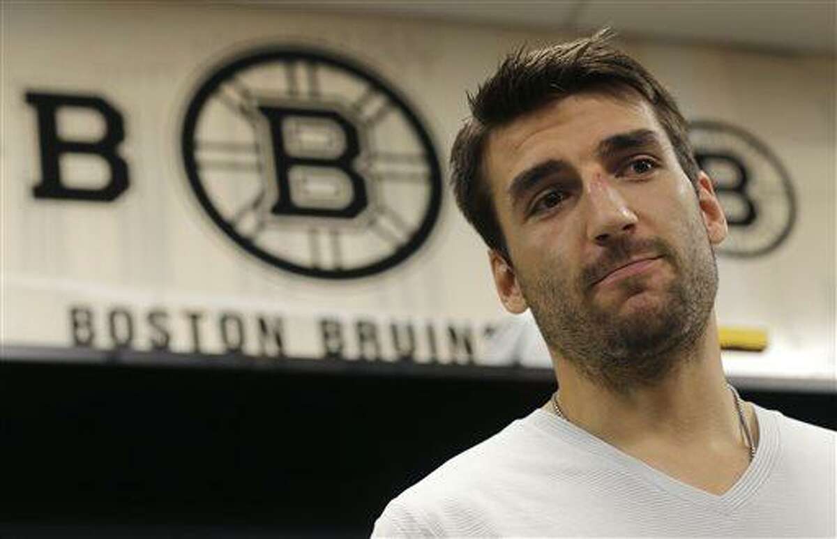 Boston Bruins center Patrice Bergeron talks with reporters in the team locker room, Tuesday, July 2, 2013, in Boston. Bergeron played through a multiple injuries including a broken rib, separated shoulder and hole in his lung during the Stanley Cup Championship. (AP Photo/Charles Krupa)