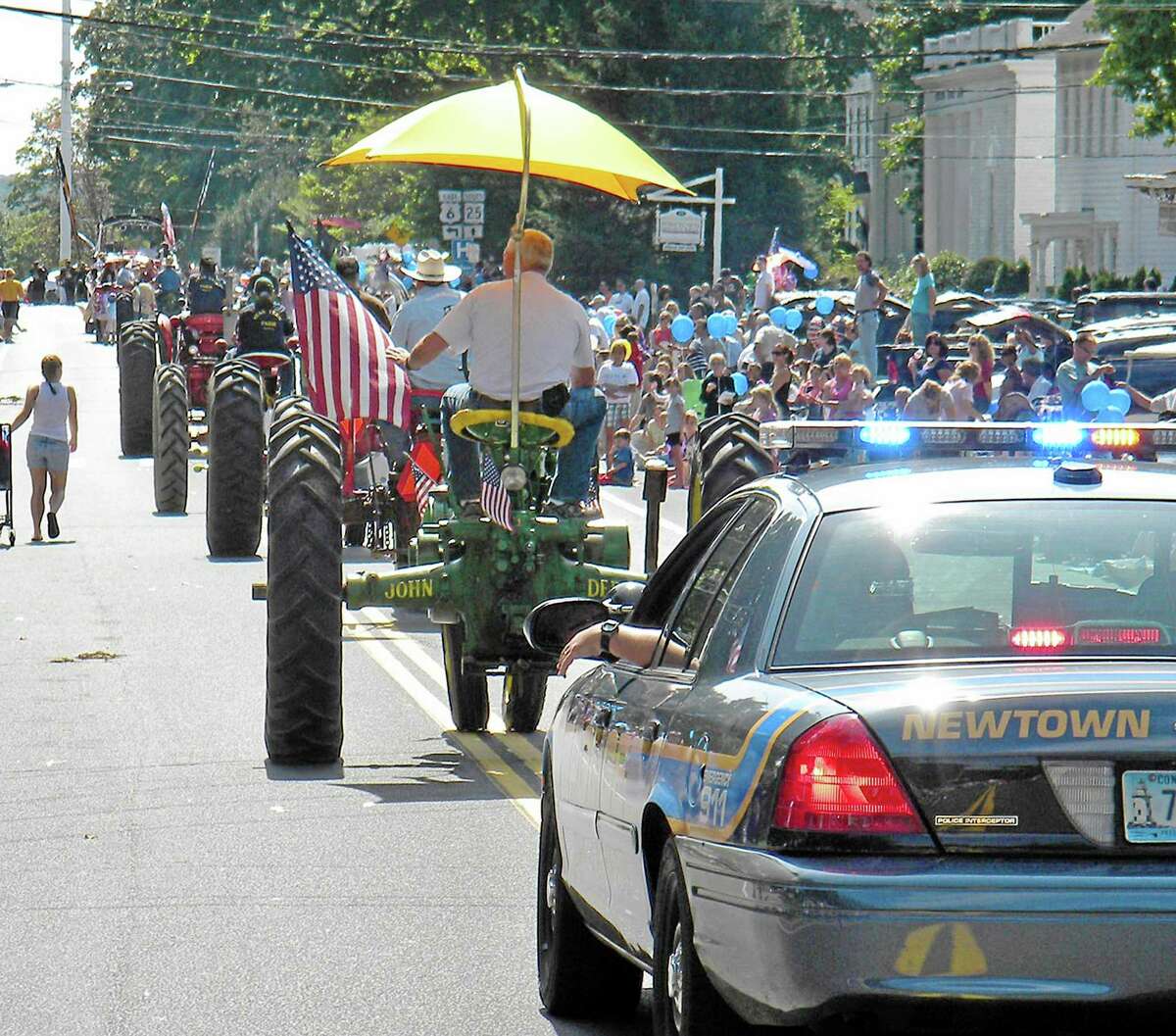In this Sept. 7, 2009, photo, a convoy of modern and antique tractors with a police escort brings up the rear of the Labor Day parade in Newtown, Conn. The town's upcoming 2013 parade faced for the first time calls and emails from regulars, folks who always marched, concerned about the most basic decision of all_how to proceed with a parade this year, nearly nine months after shootings at Sandy Hook Elementary School left 26 dead, 20 of them children. (AP Photo/Chris Sullivan)