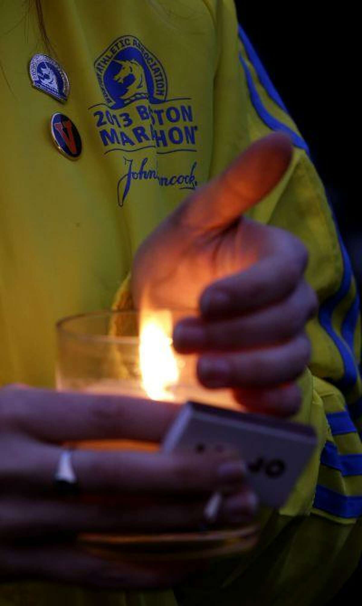 Lauren Jones, 30, of Boston, who volunteered during the Boston Marathon and was three blocks from the site of the explosions, holds a candle during a vigil for the victims at Boston Common, Tuesday, April 16, 2013. (AP Photo/Julio Cortez)