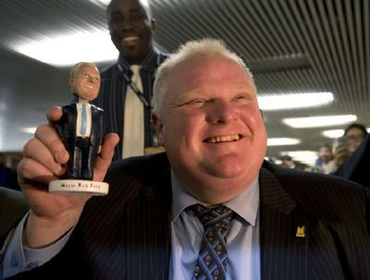 In this Tuesday, Nov. 12, 2013 file photo, Toronto Mayor Rob Ford holds a bobblehead doll depicting him at Toronto City Hall.