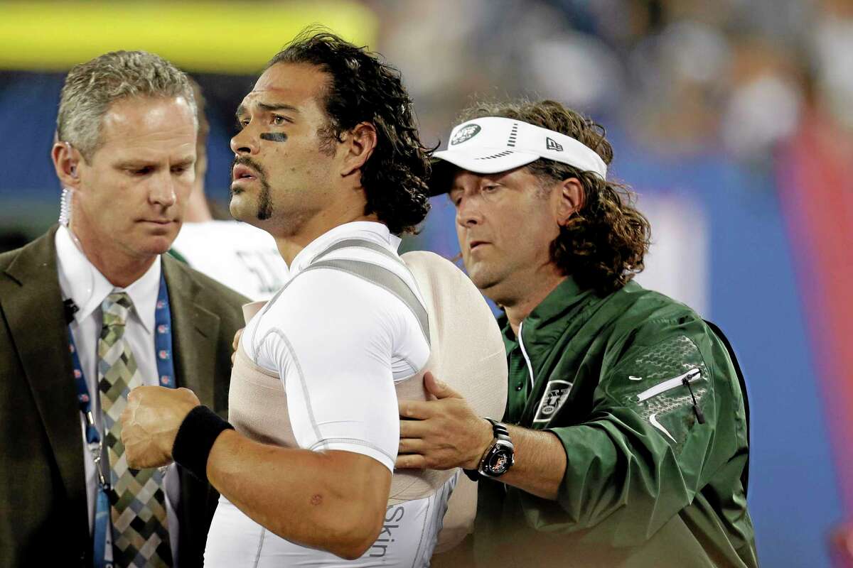 A trainer wraps New York Jets quarterback Mark Sanchez, center, during the second half of a preseason game against the Giants on Saturday.