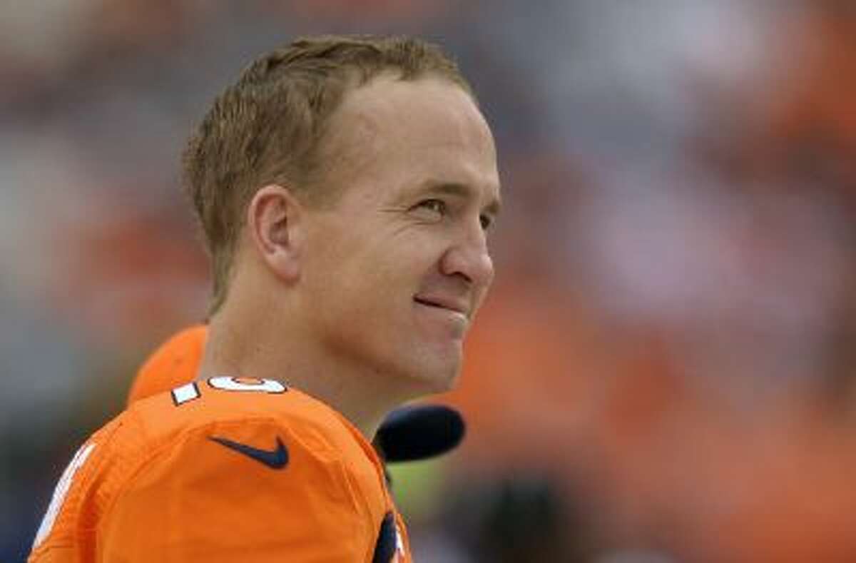 In this Sept. 29, 2013 file photo, Denver Broncos quarterback Peyton Manning watches play from the sidelines against the Philadelphia Eagles in the fourth quarter an NFL football game, in Denver. Manning returns to Indianapolis on Sunday, Oct. 20, 2013, a better quarterback than the one who left.