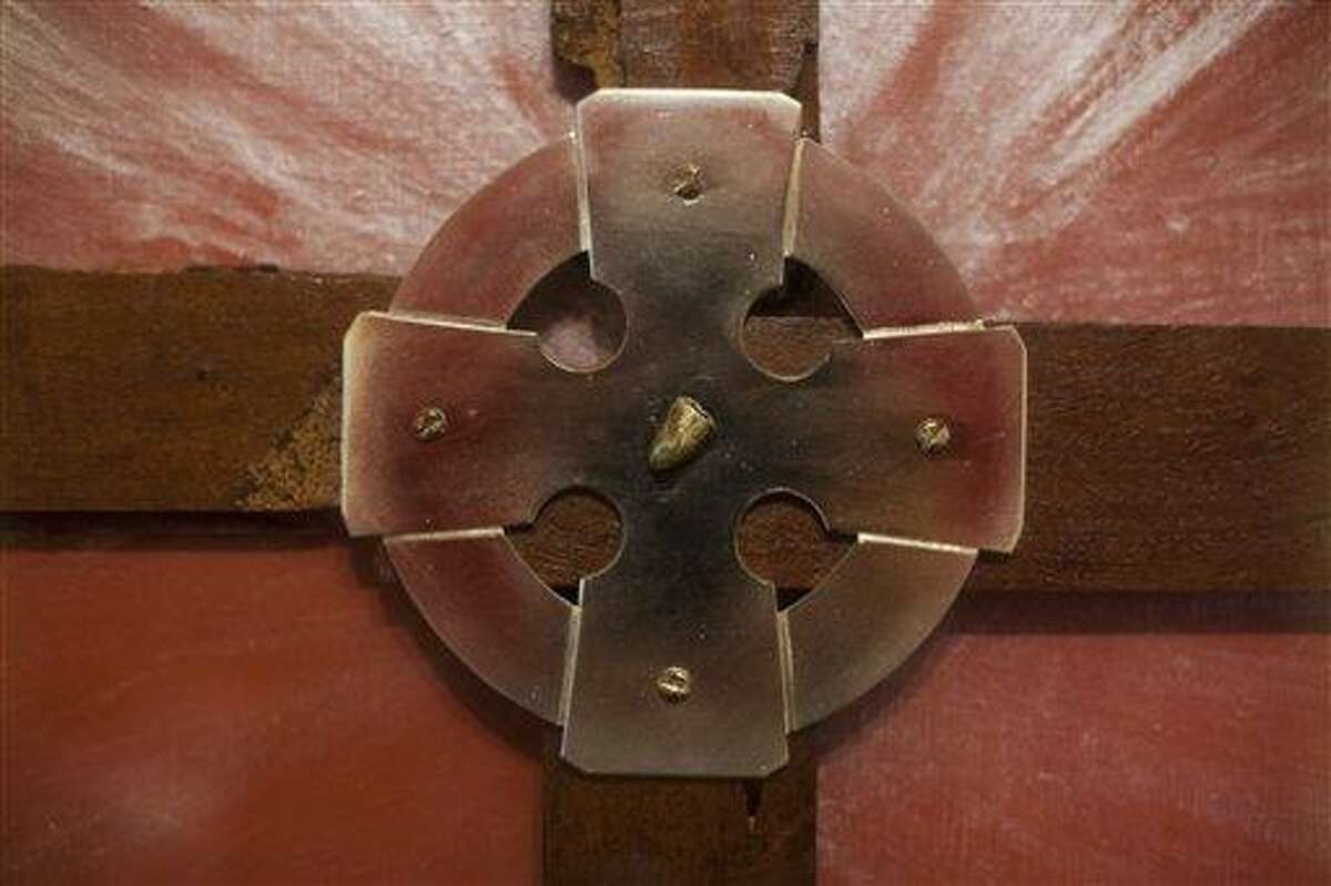 This photo taken on March 23, 2013, shows an art piece in the form of a cross with one of the bullets that was found at San Patricio church following a 1976 massacre, in Buenos Aires, Argentina. In what became known as the San Patricio Massacre, gunmen believed to be from a military unit stormed into the church after midnight on July 4, 1976, and shot to death three priests and two seminarians - the bloodiest single act of violence against the Roman Catholic Church during Argentina's brutal dictatorship. Now Catholic officials in Argentina are working to have them declared saints. And the man who promoted their cause as archbishop has become Pope Francis. (AP Photo/Victor R. Caivano)