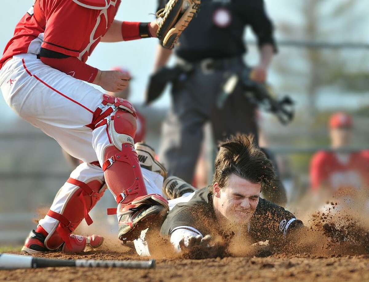 Catherine Avalone/The Middletown Press Xavier sophomore right fielder Pat Downey slides in safe as Fairfield Prep catcher Jake Berry is late with the tag Wednesday afternoon. The Xavier Falcons defeated the Fairfield Prep Jesuits 7-1 at home.